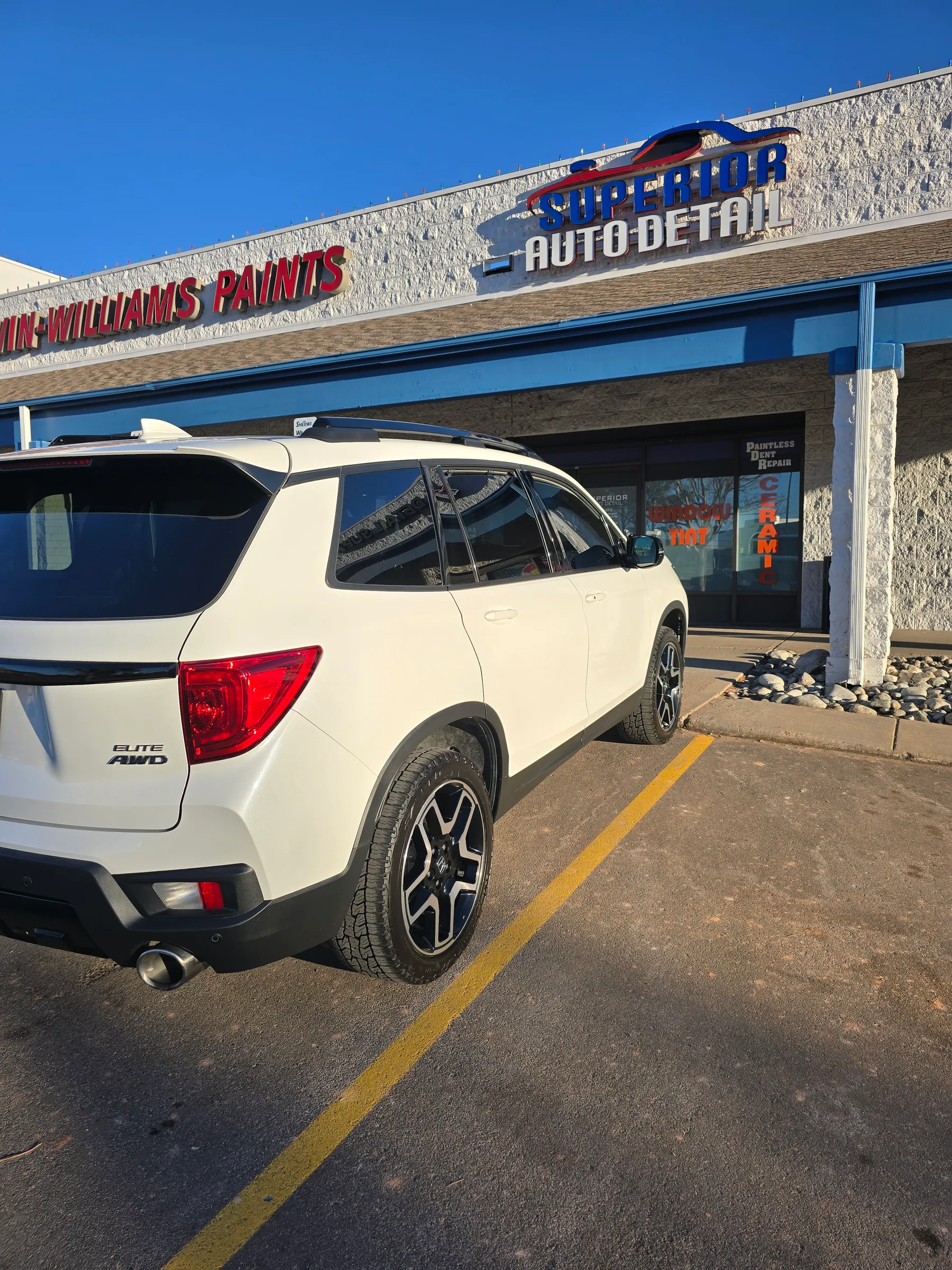 White SUV parked outside the Superior Auto Detail storefront